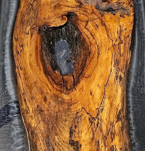 Close up of a live edge slab with silver epoxy.